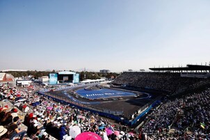 Un grand stade couvert doté d’une piste de course, entouré d’une foule de spectateurs.