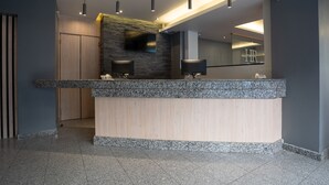 Una cocina moderna con encimeras de granito, estufa integrada y un televisor de pantalla plana en la pared.