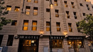 Un edificio de varios pisos con un hotel en la planta baja, un restaurante en un piso intermedio y oficinas en los pisos superiores.