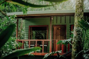 A green building with a porch, a door marked with the number 20, and a staircase leading to the entrance. - Jaguarundi Jungle Lodge (Monteverde)