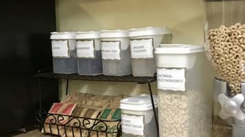 A kitchen pantry with labeled containers holding various food items like oats, organic flaxseed, and coconut sugar.