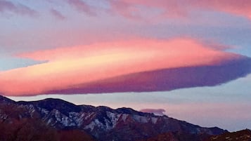 A mountain range with a pink and purple sky.