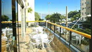 A balcony with outdoor seating, a view of the city, and a clear sky. - Tower Icaraí Hotel (Niteroi)