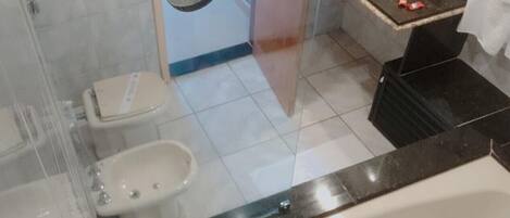 A bathroom with a toilet, bidet, and sink.