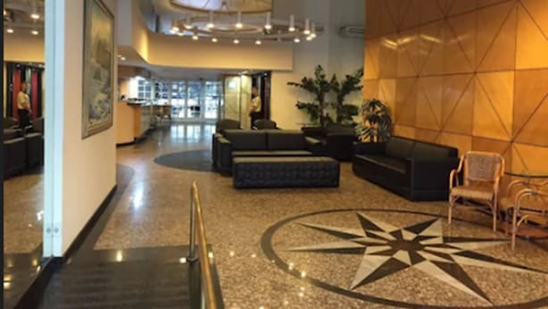 A spacious lobby with a central seating area, a large star-shaped floor design, and a modern ceiling light fixture. - Tower Icaraí Hotel (Niteroi)
