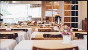 A restaurant with tables set for dining, featuring white tablecloths and wooden chairs. - Tower Icaraí Hotel (Niteroi)