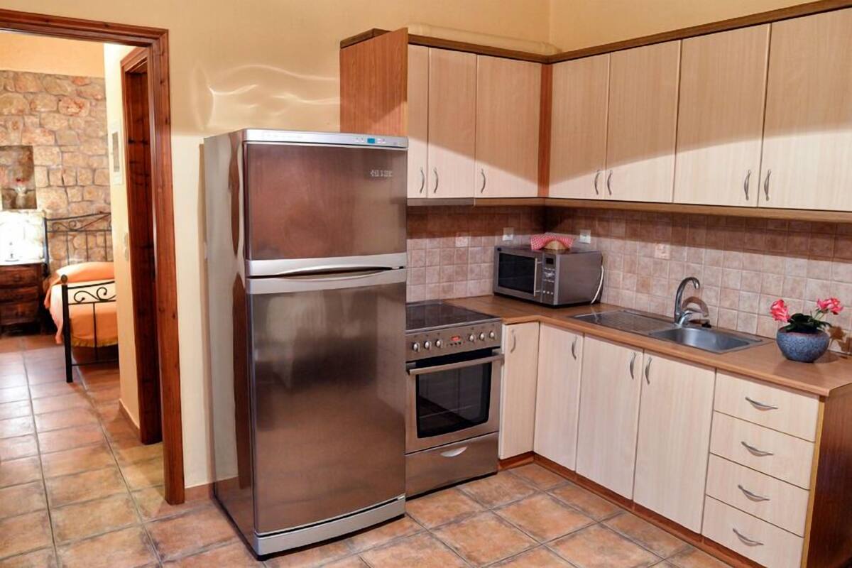 Una cocina con electrodomésticos de acero inoxidable, armarios de madera y un salpicadero de azulejos.