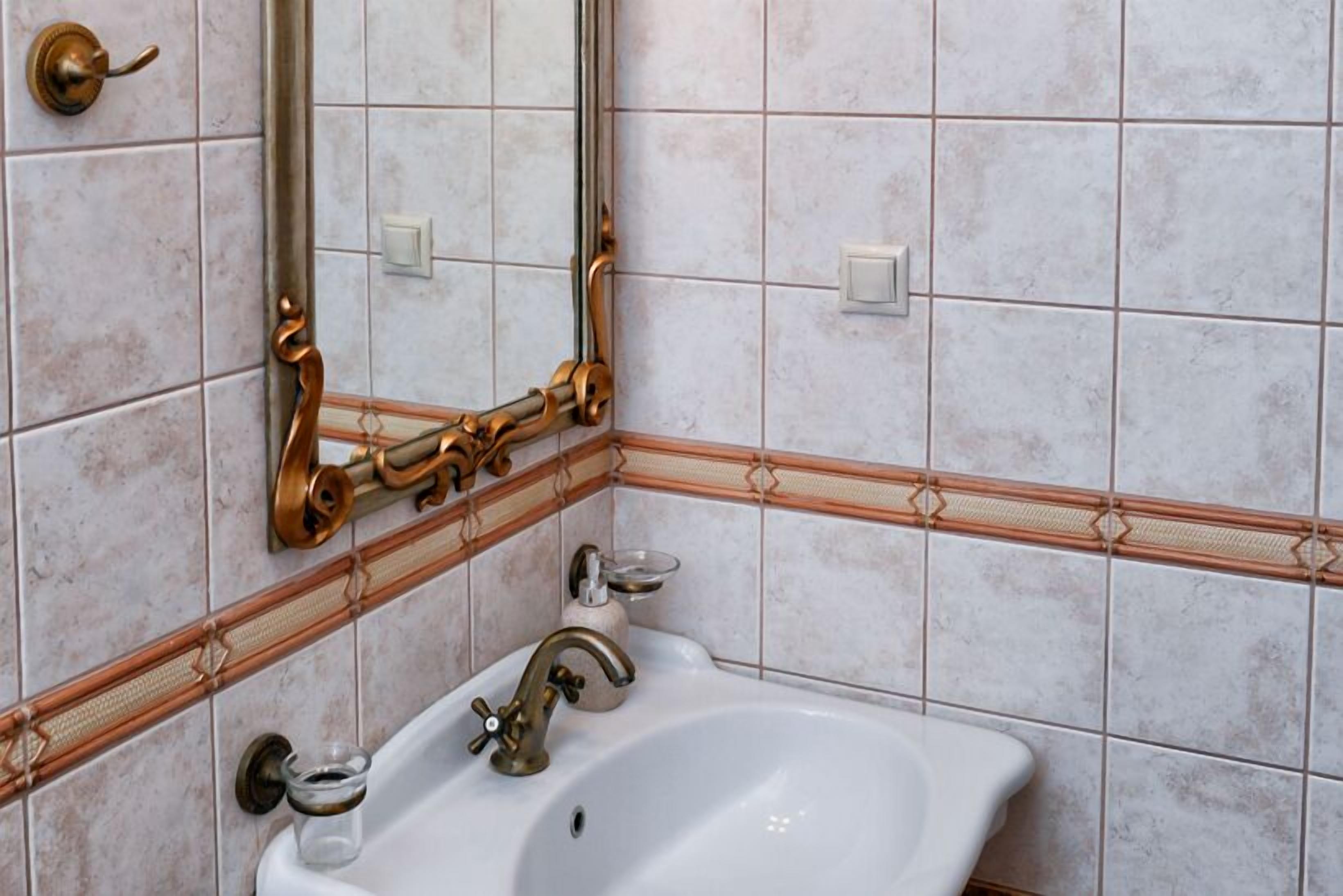 A bathroom with a white sink, a mirror, and a towel rack.