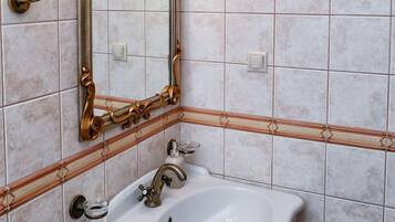 A bathroom with a white sink, a mirror, and a towel rack.