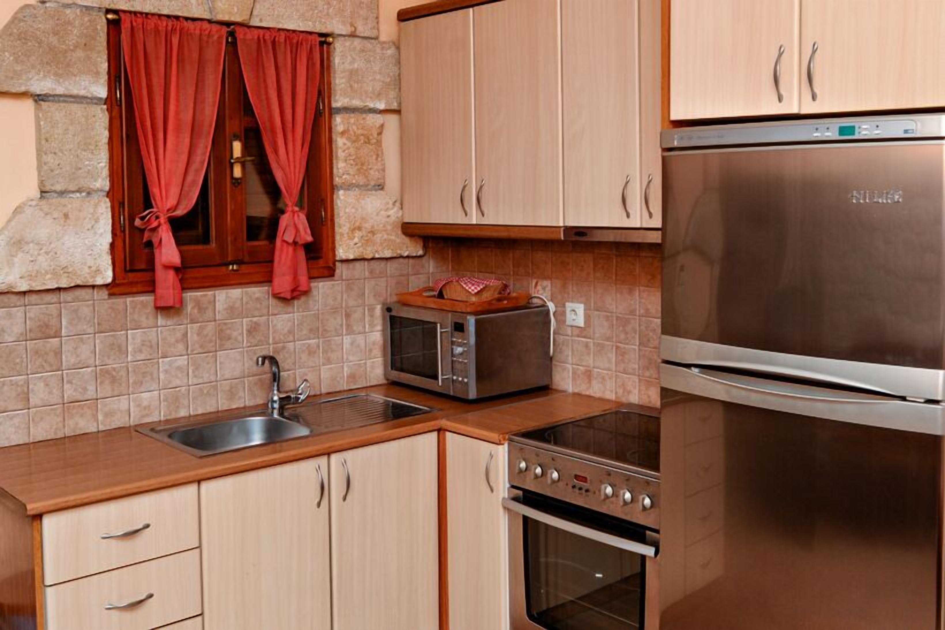 A kitchen with a sink, a microwave, a stove, and a refrigerator.