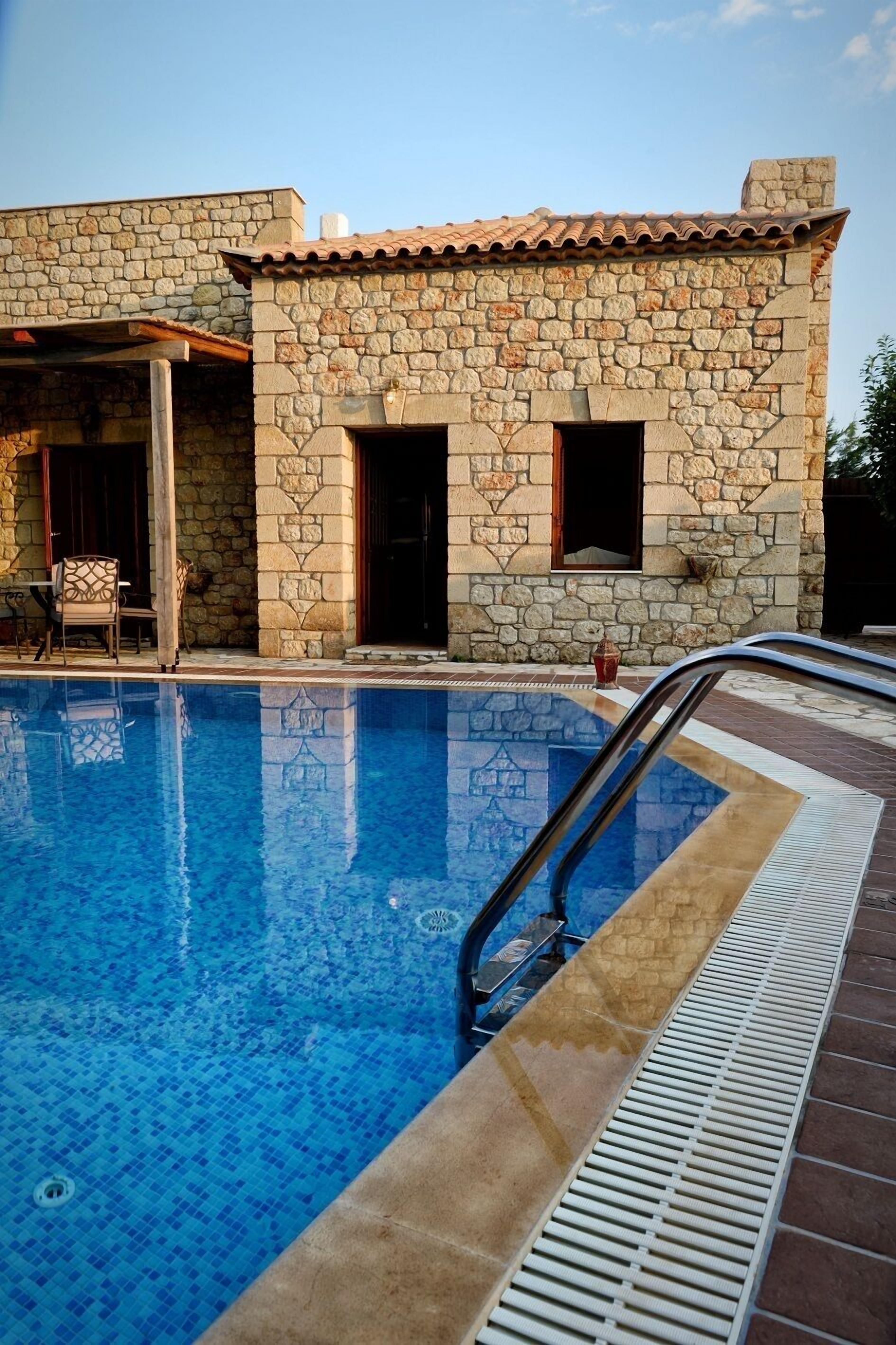 Un bâtiment en pierre avec une piscine.