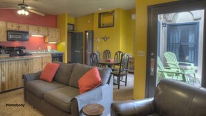 A cozy living room with a sofa, a coffee table, and a dining area with chairs and a table. - Nobody's Inn (Durango)