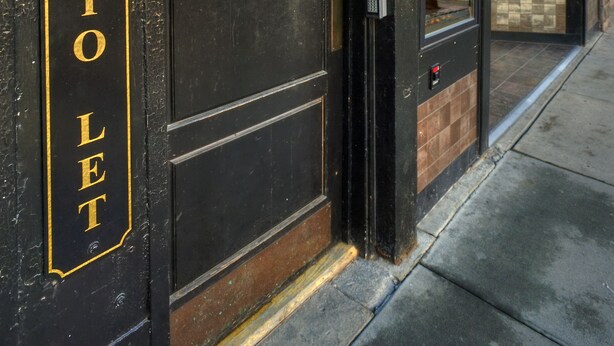 A building entrance with a sign reading "Nobody's Inn" and a door labeled "Rooms to Let." - Nobody's Inn (Durango)