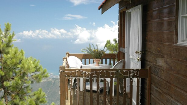 A wooden cabin with a balcony overlooking a mountainous landscape. - Ranch Le Montcel (Carrefour)
