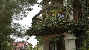 A building with a covered porch, stone pathway, and potted plants. - Ranch Le Montcel (Carrefour)