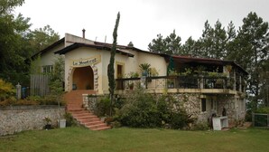 A two-story building with a stone facade, a balcony with a railing, and a sign reading "Le Mont". - Ranch Le Montcel (Carrefour)
