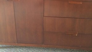 A flat-screen TV on a wooden cabinet with a remote control. - Airport Lodge Wichita Kansas (Wichita)