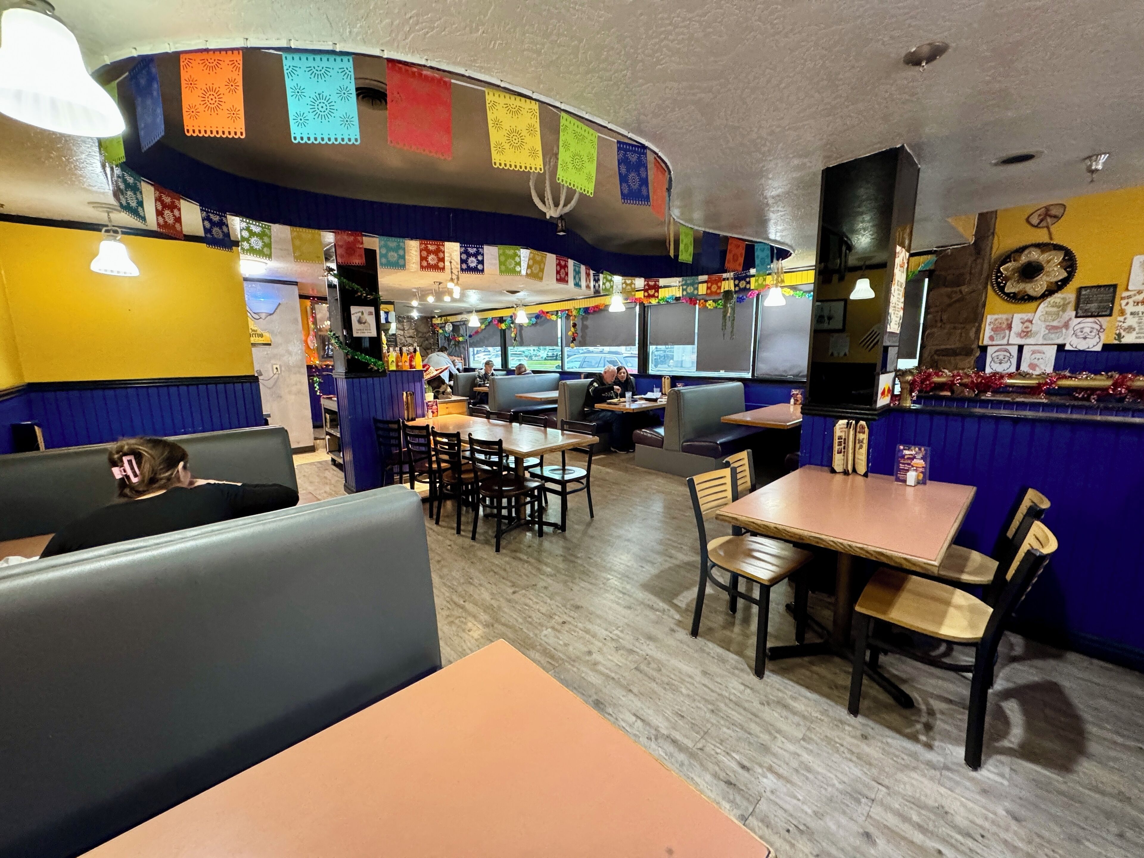Ein Restaurantinnenraum mit Sitzecken, Tischen und einer Theke.
