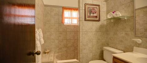 Une salle de bain avec des toilettes, une douche et un lavabo.