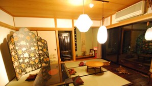 A traditional Japanese room with tatami flooring, a low table, and a shoji screen. - Hostel Yume Nomad (Kobe)