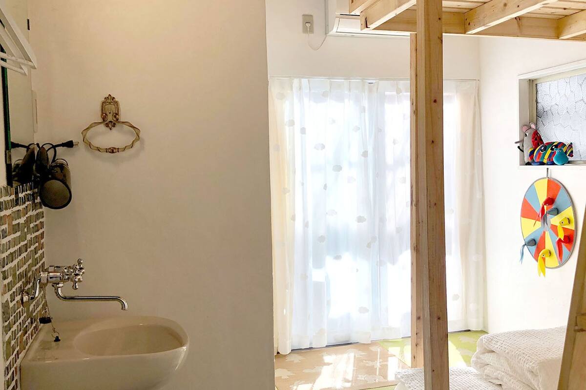 Un baño con lavabo, espejo y perchero para toallas.