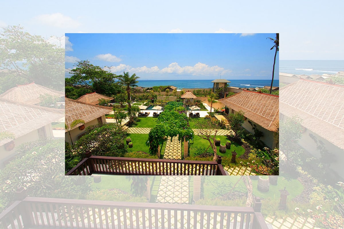 Un resort con vistas al océano, que cuenta con un patio con zonas de estar y una piscina.