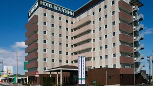A multi-story hotel with a prominent sign reading "Hotel Route Inn". - Hotel Route Inn Ishinomaki Chuo (Isinomaki)