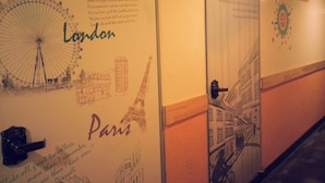 Un pasillo con paredes decoradas con bocetos y textos relacionados con Londres y París.