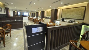 A modern restaurant with a bar area, wooden furniture, and a large decorative wall. - DREAMTEL Jakarta (Jakarta)