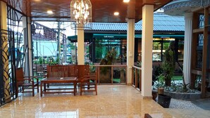 A spacious lobby with a polished marble floor, wooden benches, and a hanging light fixture. - Laos Haven Hotel (Vang Vieng)