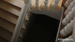A staircase with white balusters, a black vase with branches, and a window casting a shadow. - Blue Lotus Hotel (Boracay Island)