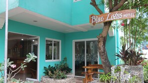 A hotel entrance with a sign reading "Blue Lotus Hotel," a tiled patio area, and a wooden bench. - Blue Lotus Hotel (Boracay Island)