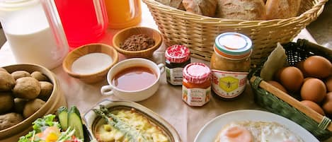 A breakfast spread with bread, eggs, sausages, and various condiments.