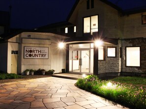 A building with a sign reading "Resort Inn North Country" and a stone facade. - Resort Inn North Country (Furano)