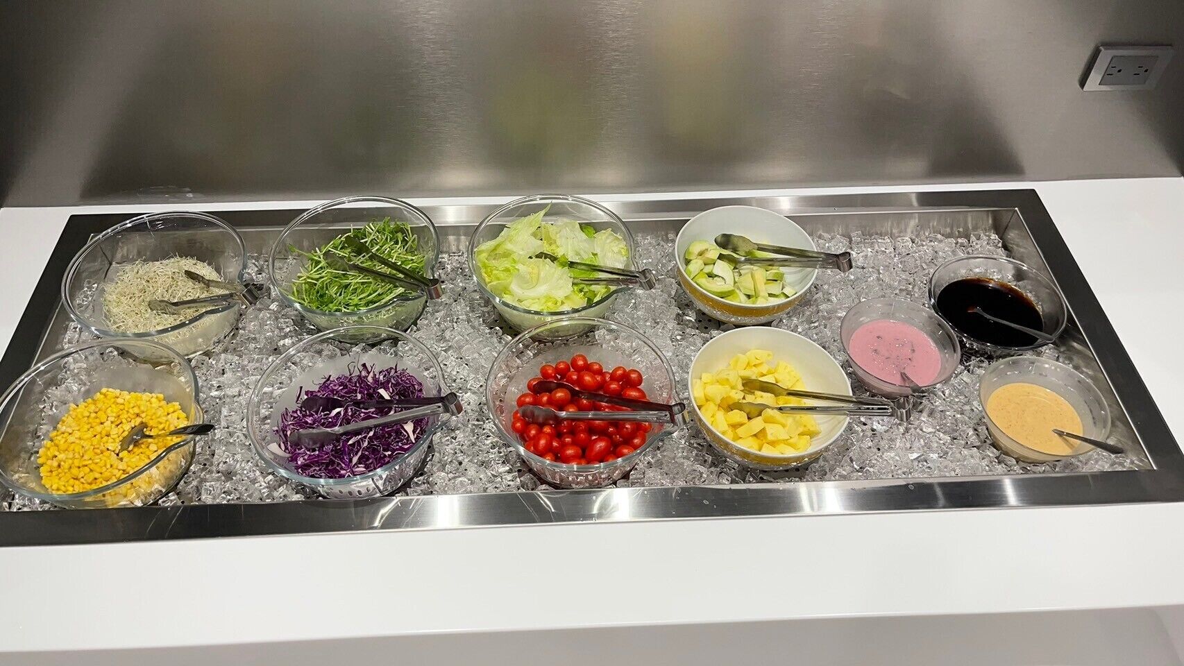 A buffet with various food items on ice trays.