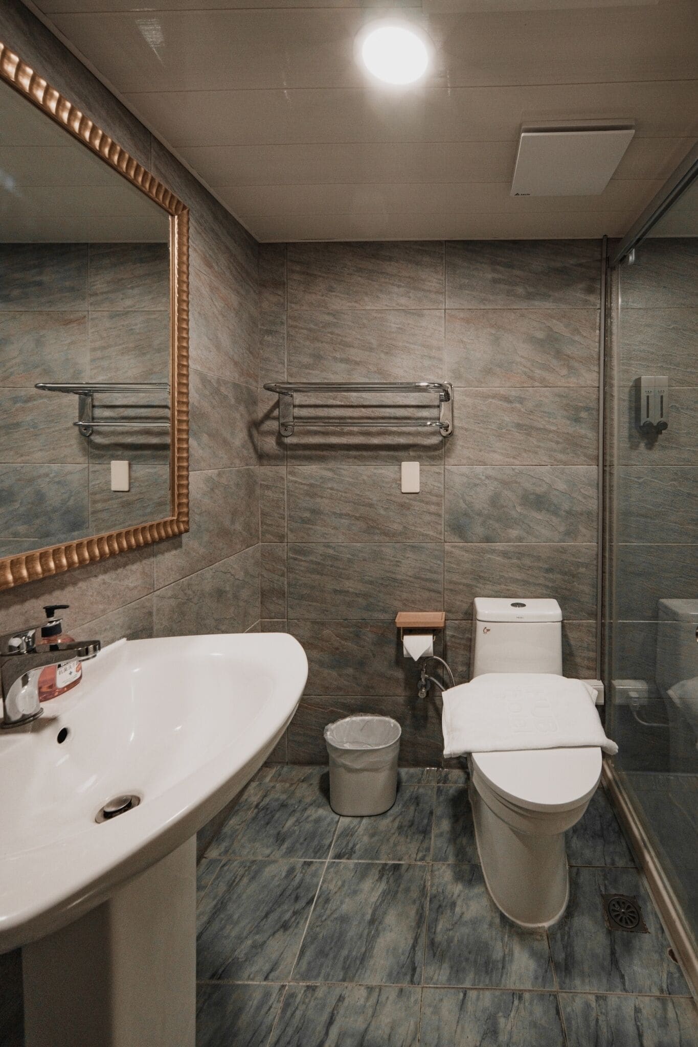 A modern bathroom with a large sink, toilet, and shower.