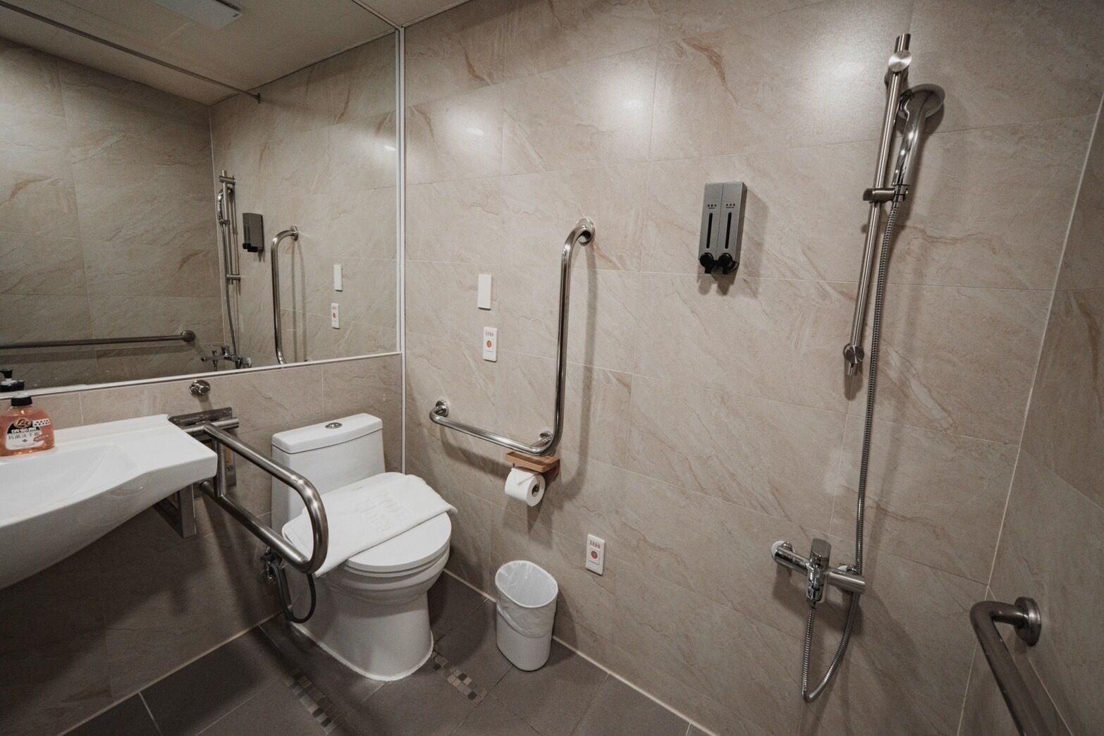Un baño moderno con inodoro, lavamanos y ducha.