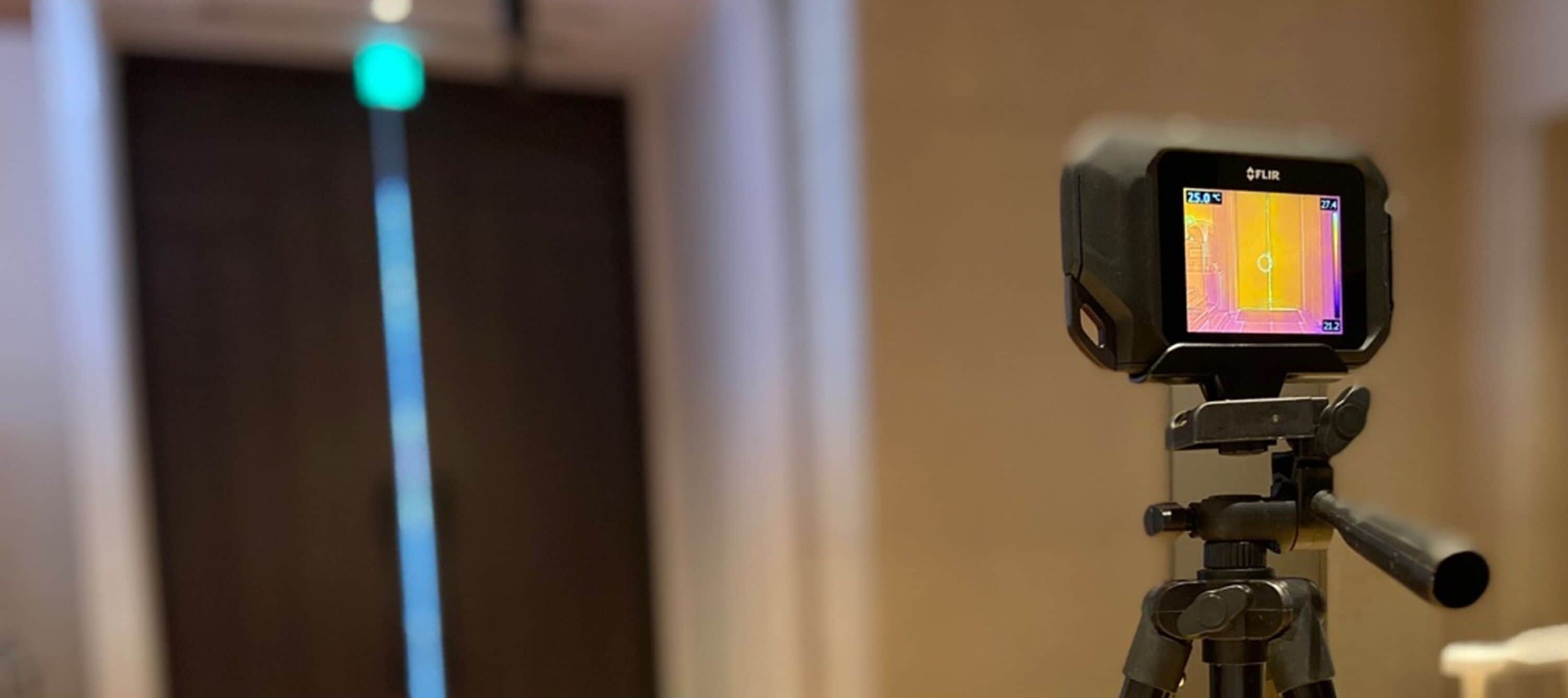 A FLIR thermal imaging device mounted on a tripod.