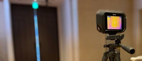 A FLIR thermal imaging device mounted on a tripod.