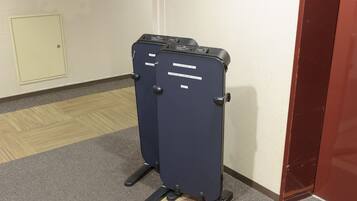 Two upright luggage racks in a hallway.