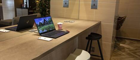 Ein moderner Empfangstresen mit Laptops, einer Kaffeetasse und einer Pflanze.