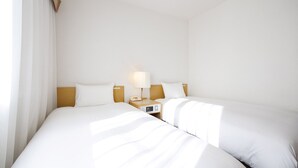 A hotel room with two beds, a bedside table with a lamp, a clock, and a phone. - Court Hotel Mito (Mito)