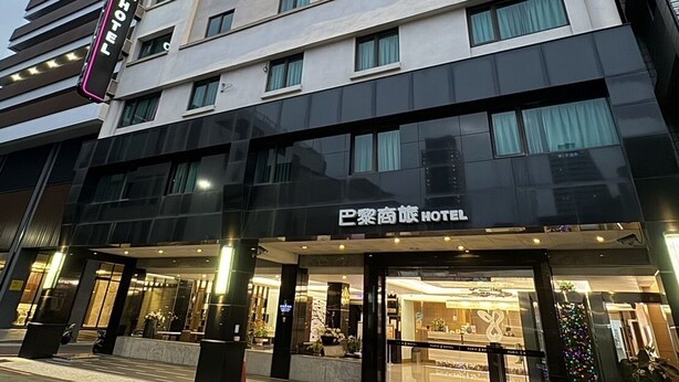 A hotel with a modern facade, multiple floors, and a prominent sign indicating it is a hotel. - Paris Business Hotel (Kaohsiung)