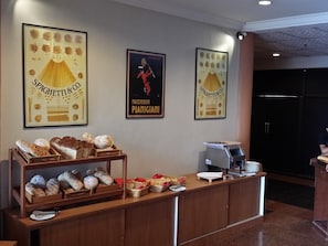 A reception area with a bread display, posters, a coffee machine, and a counter. - Best Star Resort (Langkawi)