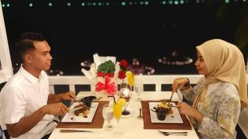 A couple dining at a table with a view of the night sky.