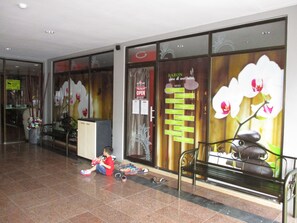 A lobby with a reception desk, a child playing with toys, and a spa sign. - Best Star Resort (Langkawi)