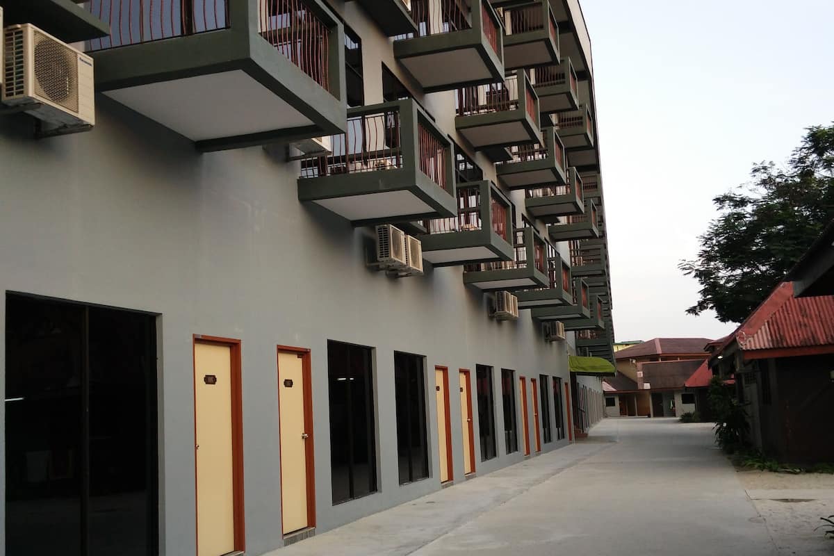 A modern building with multiple balconies and air conditioning units.