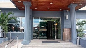 A building entrance with a wooden ceiling, glass doors, and a staircase leading up. - Townhouse Oak Vera Hotel Near Clark International Airport (Angeles City)