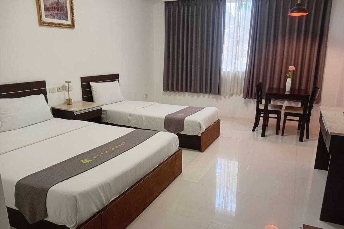 Una habitación de hotel con dos camas, un escritorio y una silla.
