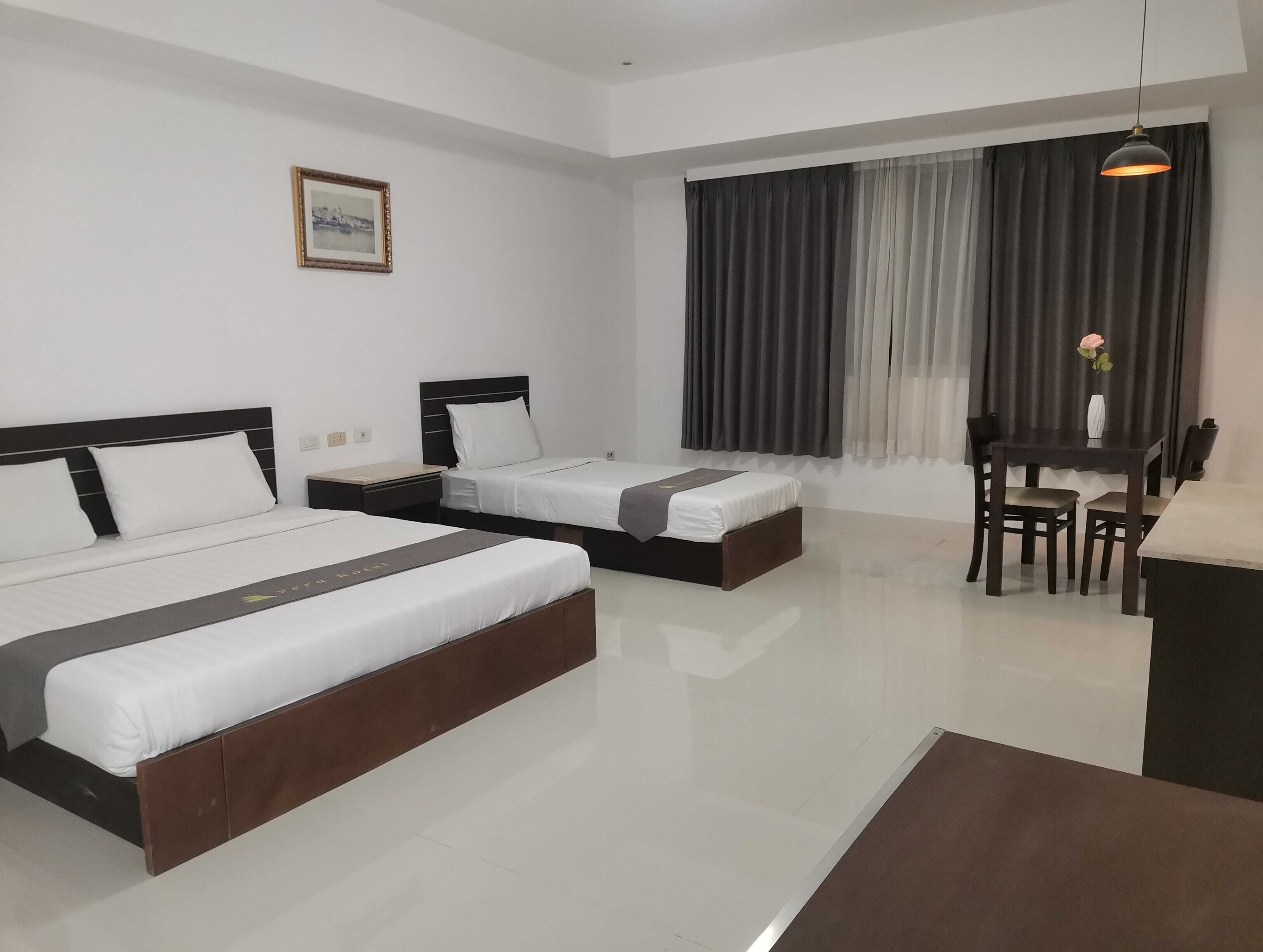 Une chambre d’hôtel avec deux lits, une table à manger et une chaise.